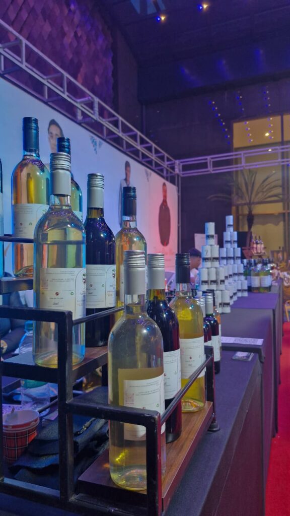 Tiewdohmaw Wine brand display at trade fair with bottles of wild fruit and berry wines made in Meghalaya using organic fermentation.
